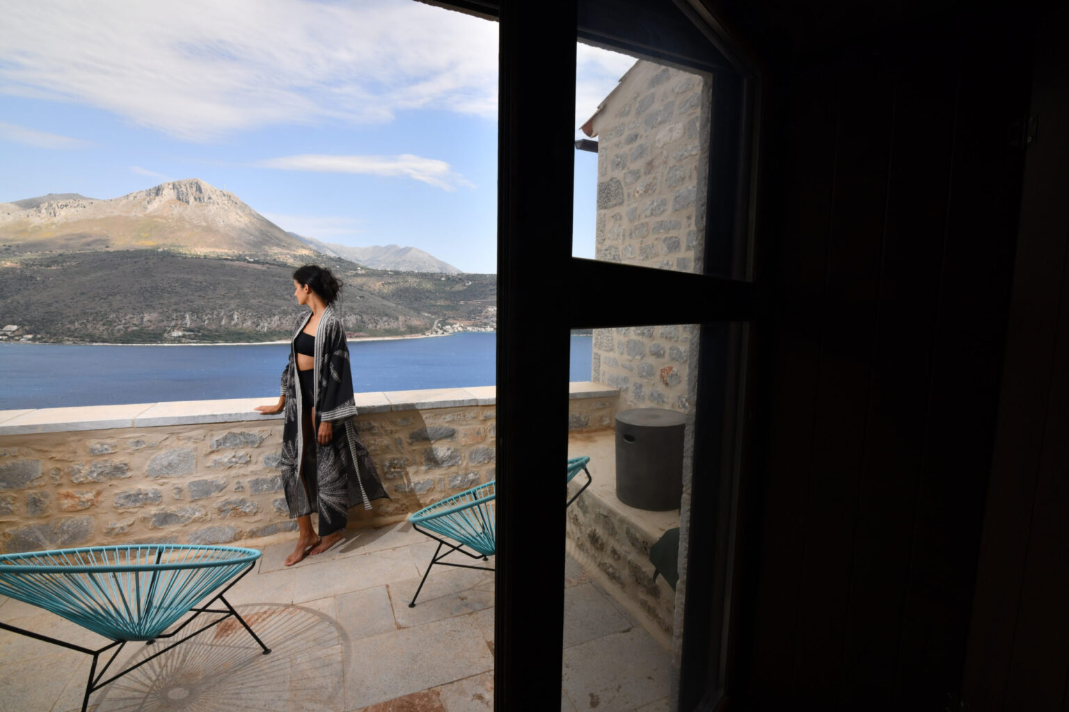 Guest on a stone terrace at Petra & Fos overlooking Oitylo Bay and the Mani mountains