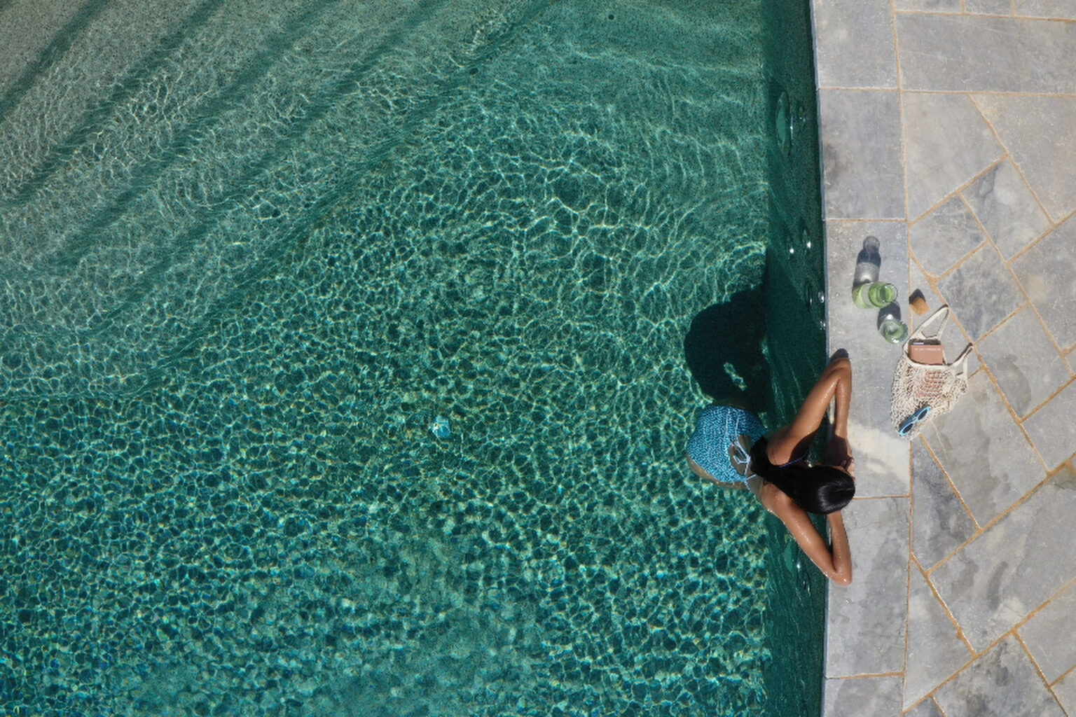 Aerial view of a guest at the stone edge of the Petra & Fos infinity pool